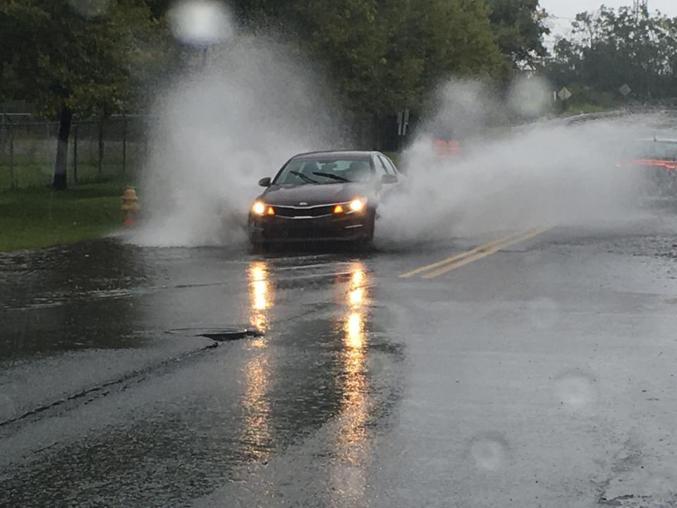 A car drives through pooling water on 12th Street near I-495 in Delaware in 2019.