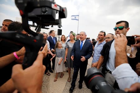 Members of the media work as Israeli Prime Minister Benjamin Netanyahu walks after holding a weekly cabinet meeting in the Jordan Valley, in the Israeli-occupied West Bank