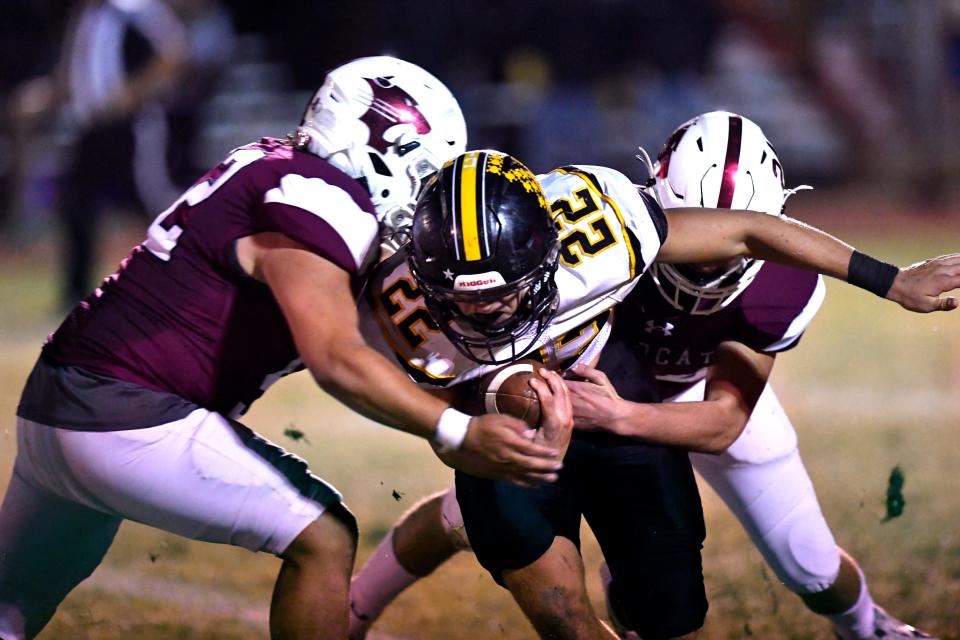 Hawley defensive lineman Joseph Cadena (left) and linebacker Allyn Barker tackle Cisco running back Trenton Huston during Friday's District 4-2A D I championship in Hawley.