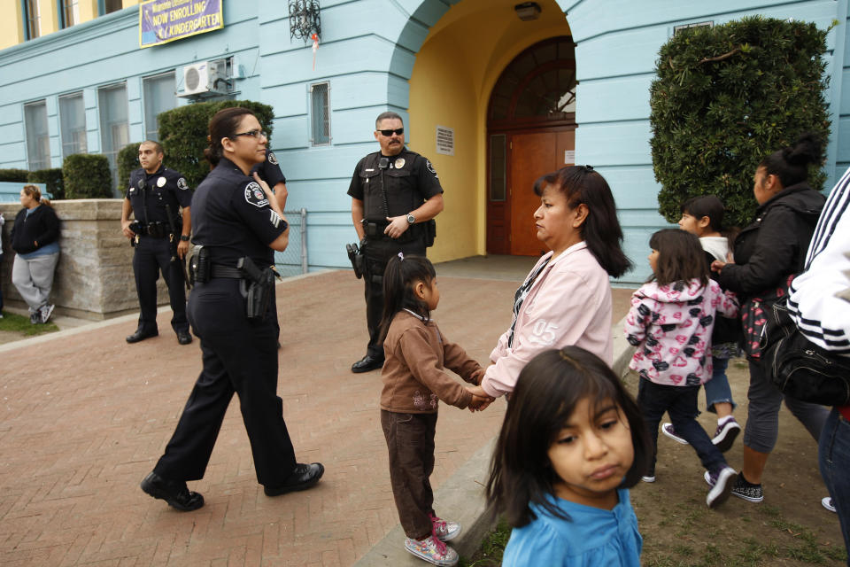 Los Angeles School Police officers provide security as parents and children gather outside of Miramonte Elementary school to protest as investigation continues into bizarre sexual abuse scandal in Los Angeles