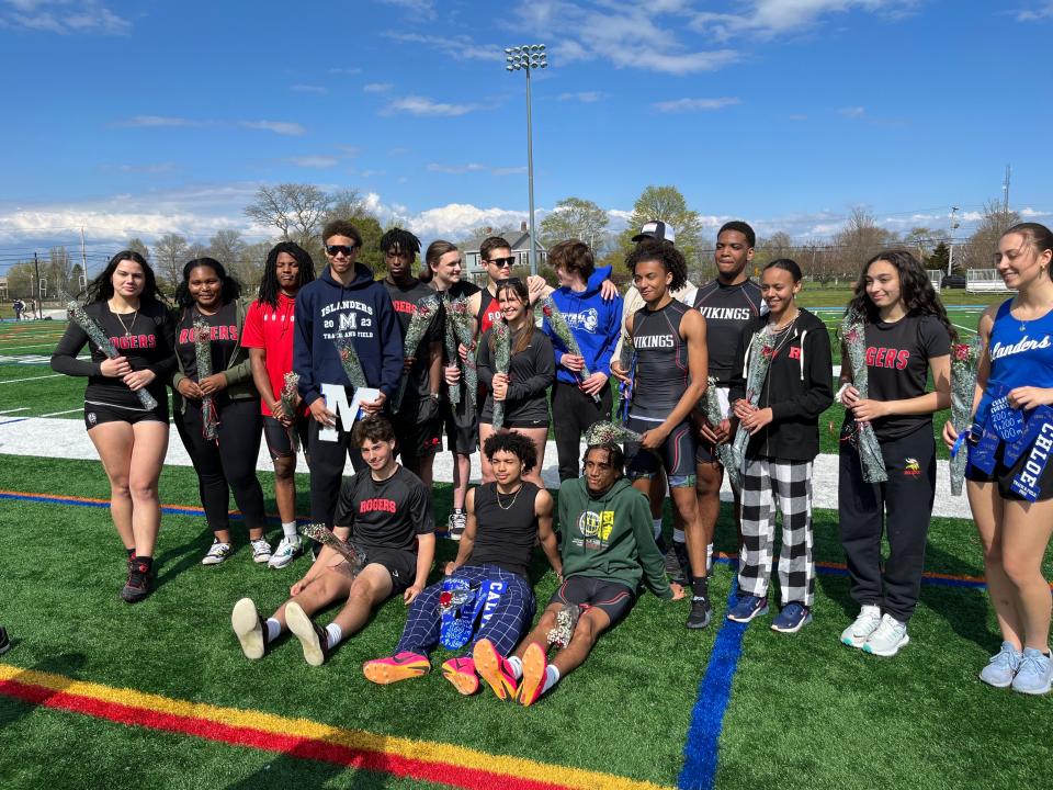 Senior members of the Rogers and Middletown high school track teams pose for a photo together last week. The Rogers girls team defeated Middletown 81-56 and the Vikings boys downed the Islanders 119-26.