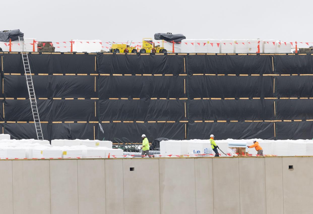 Workers move materials on the roof of the Pro Football Hall of Fame Village water park in late 2023.