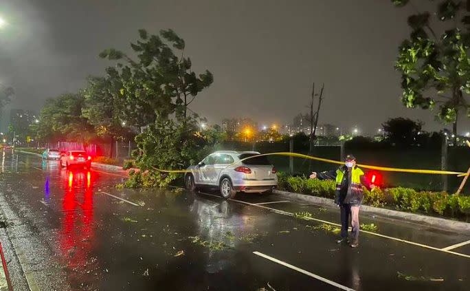 ▲杜蘇芮颱風來勢洶洶，攜大量雨勢侵襲南台灣，高雄市區從昨晚便出現多起路樹倒塌事件，前鎮區時代大道路樹砸中停放在路旁的保時捷「凱燕」（圖／翻攝畫面）