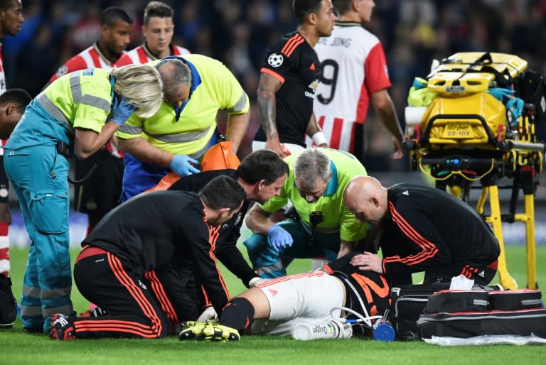 Manchester United defender Luke Shaw receives treatment for a double fracture of the leg during the UEFA Champions League football match between Eindhoven and Manchester United at the Philips stadium on September 15, 2015