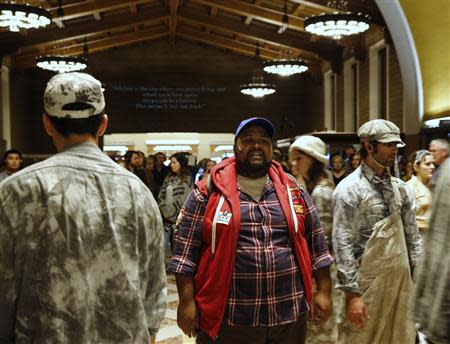 A member of the L.A. Dance Project portraying Marco Polo (in red jacket) performs the opera "Invisible Cities" at Amtrak's Union Station in Los Angeles November 15, 2013. REUTERS/Fred Prouser