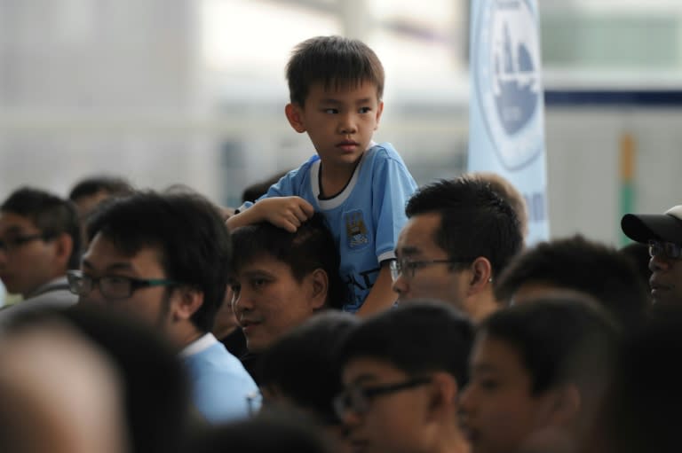 A young fan waits for the arrival of Manchester City players in Hong Kong