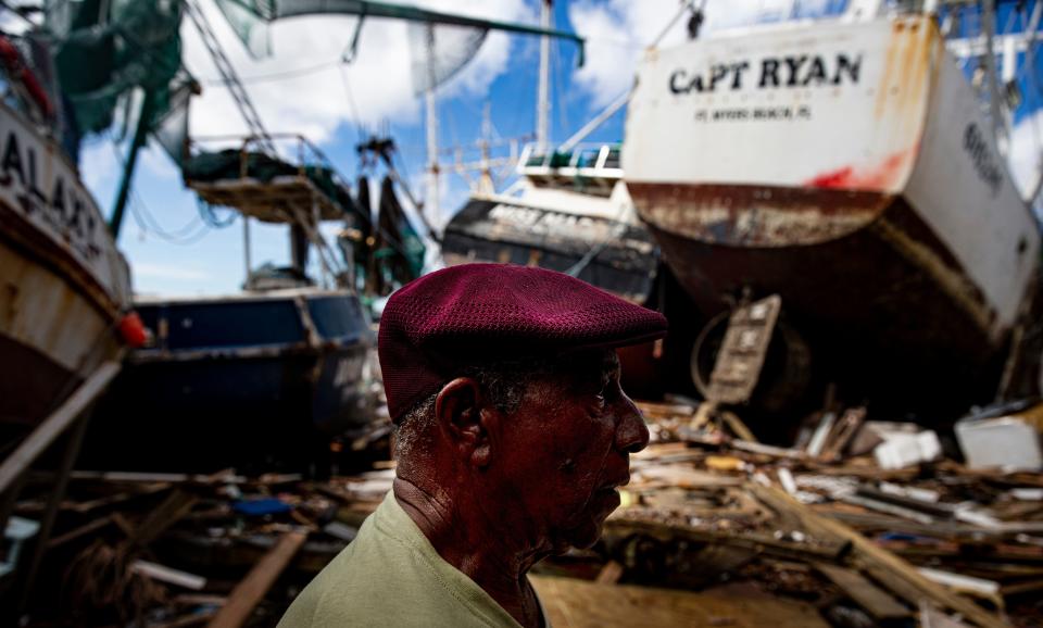 Two weeks after Hurricane Ian, Leonard Hunte, 77, a lifelong shrimper, surveys damage to shrimp boats that were washed ashore by storm surge from the Category 4 hurricane. He rode out the storm at his home at a nearby trailer park. He plans on shrimping when the boats are back in the water, until he turns 80.