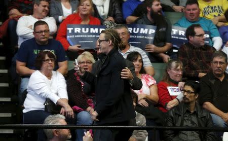 A heckler is escorted out of the arena by security as U.S. Republican presidential candidate Donald Trump speaks during a campaign rally in Grand Rapids, Michigan December 21, 2015. REUTERS/Rebecca Cook