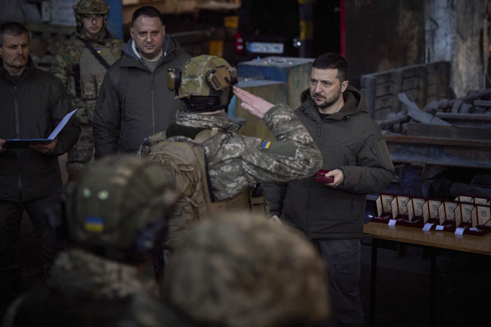 En esta imagen proporcionada por la oficina de prensa de la presidencia ucraniana, el presidente de Ucrania, Volodymyr Zelenskyy, a la derecha, entrega una medalla a un militar en la disputada ciudad de Bakhmut, escenario de duras batalla con tropas invasoras rusas, en Ucrania, el martes 20 de diciembre de 2022. (Oficina de prensa de la presidencia ucraniana vía AP)