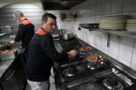 Customers enjoy dinner sitting inside a motorhome camper parked at the Belgian restaurant Matthias And Sea in Tarcienne