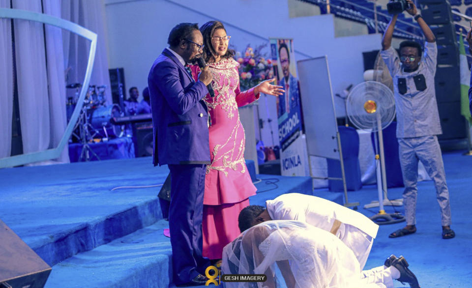 In this photo provided by Gesh Creatives, Eunice Dwumfour and husband and fellow pastor Peter Ezechukwu kneel before Champions Royal Assembly founder Joshua Iginla and wife Stella Iginla at their Nov. 24, 2022 marriage ceremony in Abuja, Nigeria. The 30-year-old Dwumfour, a Sayreville, New Jersey councilwoman, was gunned down as she arrived home in Sayreville on Feb. 1 by an unknown assailant. (Gesh Creatives via AP)
