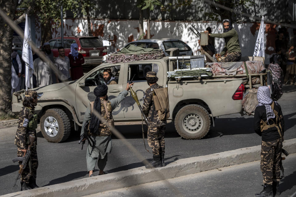 Taliban fighters stand guard at the explosion site, near a mosque, in Kabul, Afghanistan, Friday, Sept. 23, 2022. An explosion went off near a mosque in Afghanistan's capital on Friday, with police confirming casualties. A column of black smoke rose into the sky and shots rang out several minutes after the blast in the city's diplomatic quarter. (AP Photo/Ebrahim Noroozi)