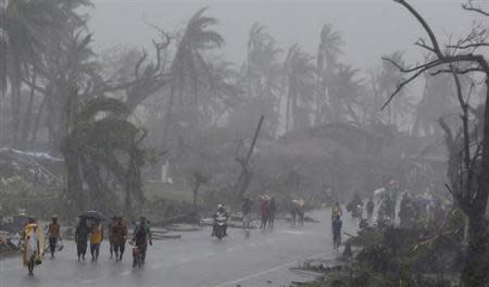 Survivors walk on a road amidst heavy downpour after Typhoon Haiyan battered Tacloban city in central Philippines November 10, 2013. REUTERS/Erik De Castro