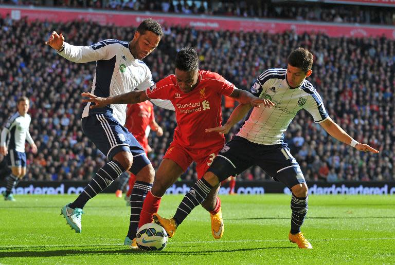 Liverpool's Raheem Sterling (C) is tackled by West Bromwich's Cristian Gamboa (R) and Joleon Lescott during their English Premier League match at Anfield on October 4, 2014