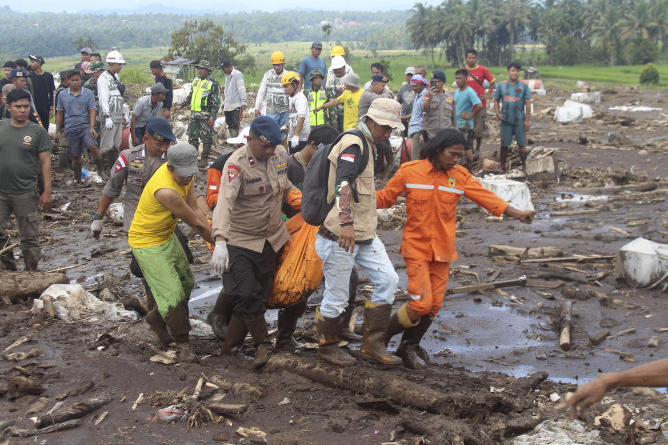 Un grupo de rescatistas traslada el cadáver de una víctima de una inundación repentina registrada en Tanah Datar, en la provincia de Sumatra Occidental, Indonesia, el lunes 13 de mayo de 2024. (AP Foto/Ali Nayaka)