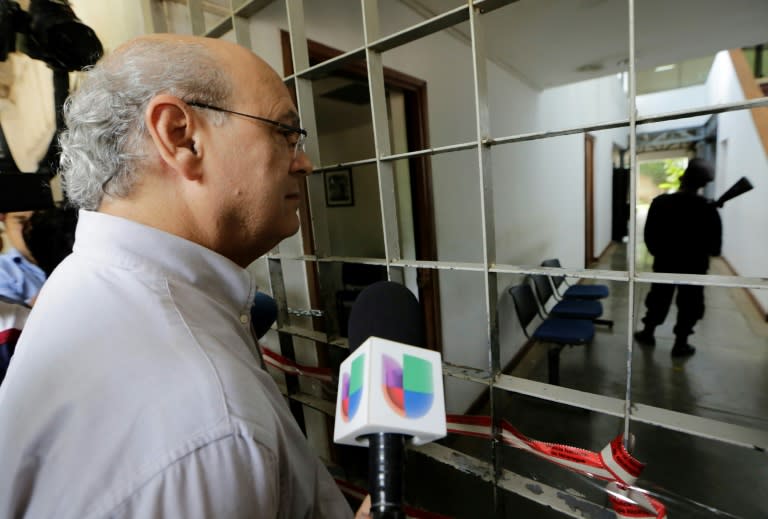 Nicaraguan journalist Carlos Fernando Chamorro looks at riot policemen standing guard and barring entry inside a building he owns in Managua on December 15, 2018