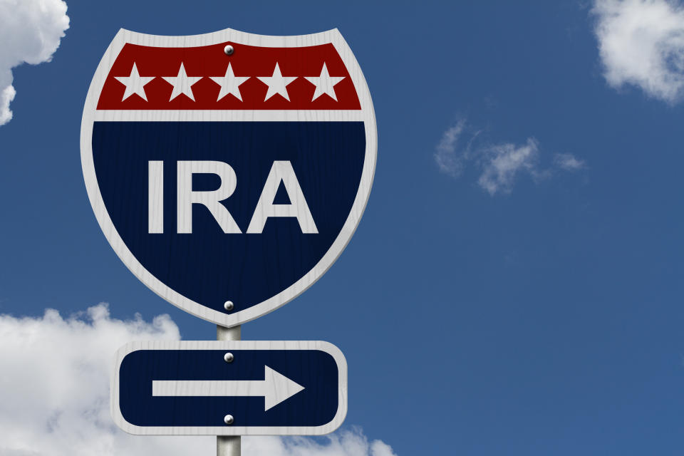 Interstate road sign marked IRA with a directional arrow, and blue sky with a few clouds above.