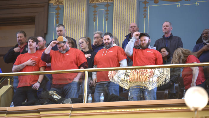 FILE - Union members, supporters and others put their hats back on after reciting the Pledge of Allegiance, Tuesday morning, March 14, 2023. Michigan, long known as a mainstay of organized labor, became the first state in decades to repeal a union-restricting law known as “right-to-work” that was passed over a decade ago by a Republican-controlled Legislature. (Todd McInturf/Detroit News via AP)