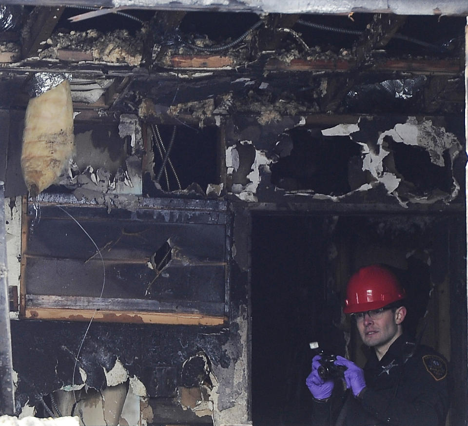 A fire department photographer investigates the upper floor of a house fire on the 700 block of W. Oakton that claimed the lives of 5 people, Wednesday, Jan. 27, 2021, in Des Plaines, Ill. (Mark Welsh/Daily Herald via AP)