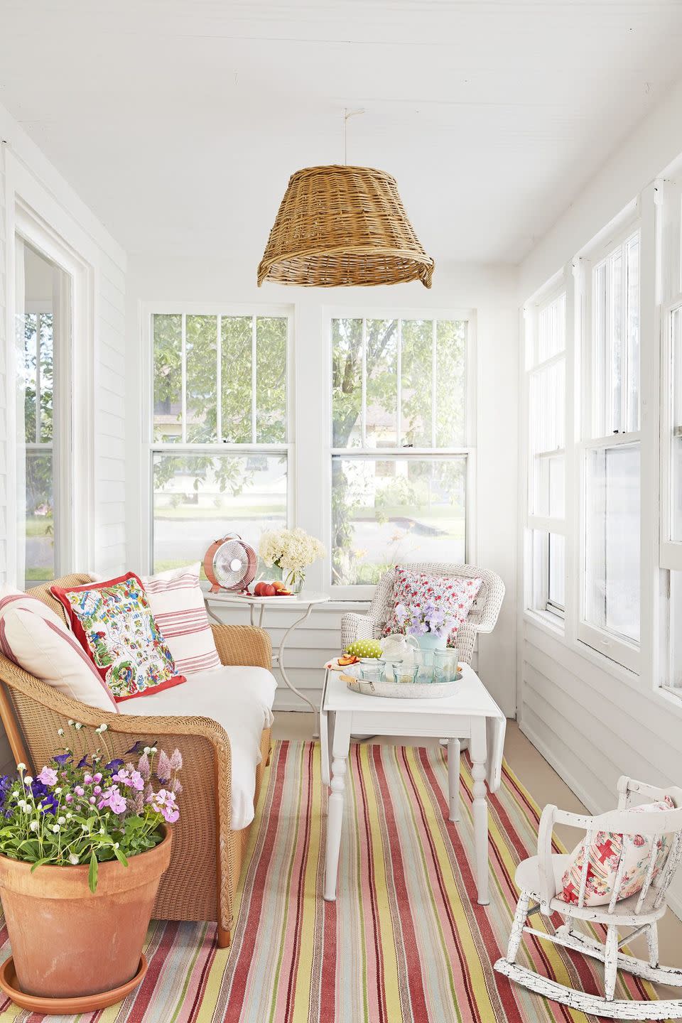 sunporch with floral pillows and striped rug