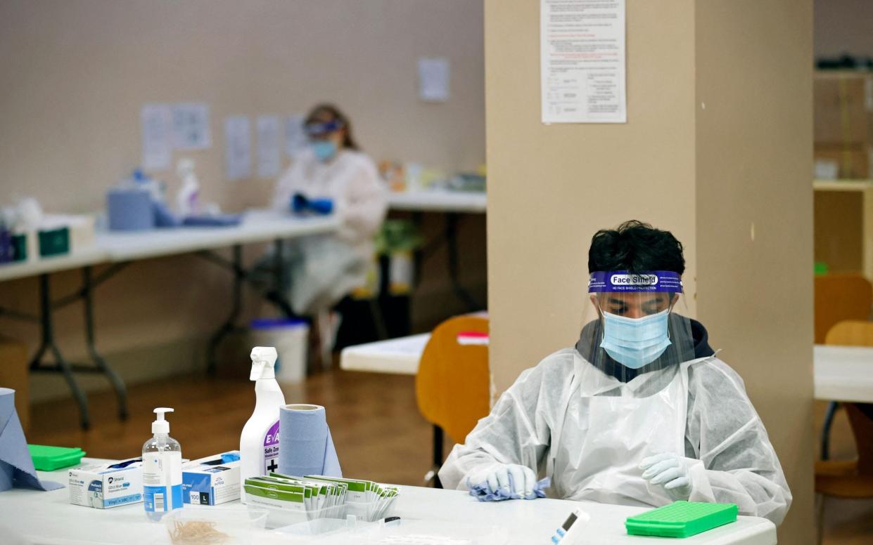 A health worker processes Covid-19 lateral flow tests at a NHS Test and Trace unit in Uxbridge, Hillingdon, west London on May 25, 2021. The report says that at times there was extra capacity at some labs that was not used. - Adrian Dennis/ AFP