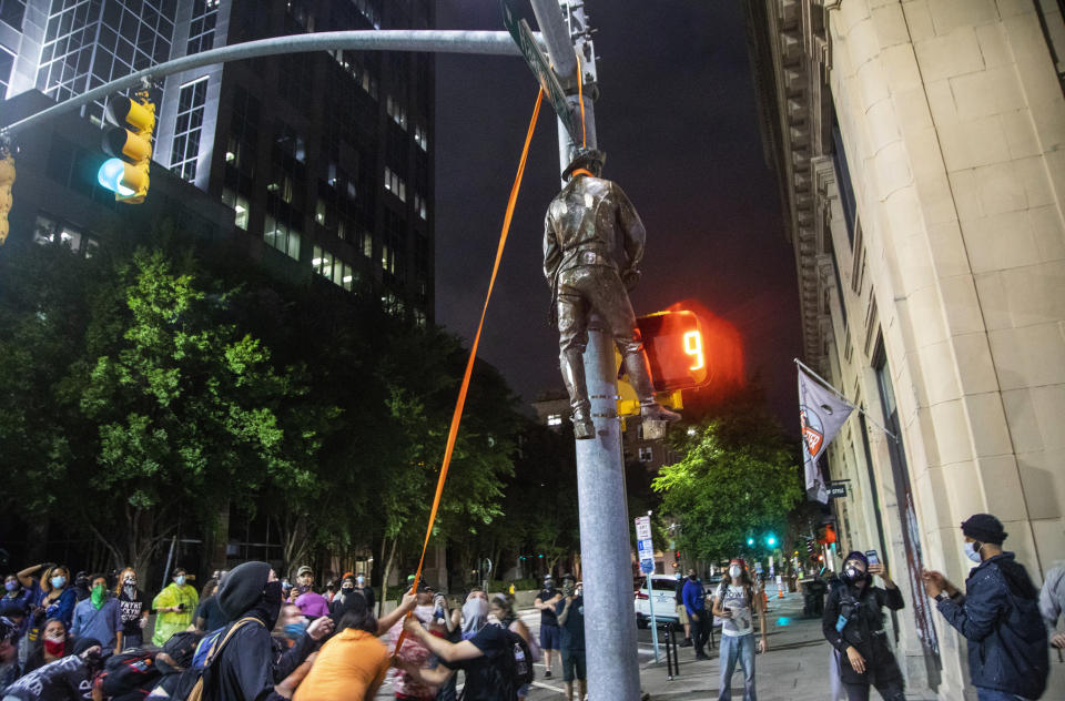 Protesters lynch a figure pulled from the Confederate monument at the State Capitol at the intersection of Salisbury and Hargett Streets in Raleigh, N.C., on Juneteenth, Friday, June 19, 2020. (Travis Long/The News & Observer via AP)
