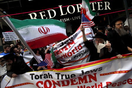 A group of orthodox Jewish counter-demonstrators wave American and Iranian flags as they stand amid protestors who were demonstrating against the nuclear deal with Iran during a rally in Times Square in the Manhattan borough of New York City, July 22, 2015. REUTERS/Mike Segar