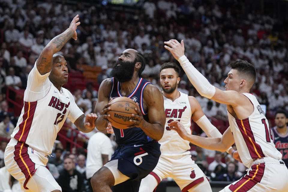 Philadelphia 76ers guard James Harden, center, goes up for a shot against Miami Heat forward P.J. Tucker (17) and guards Max Strus (31) and Tyler Herro, right, during the first half of Game 5 of an NBA basketball second-round playoff series, Tuesday, May 10, 2022, in Miami. (AP Photo/Wilfredo Lee)