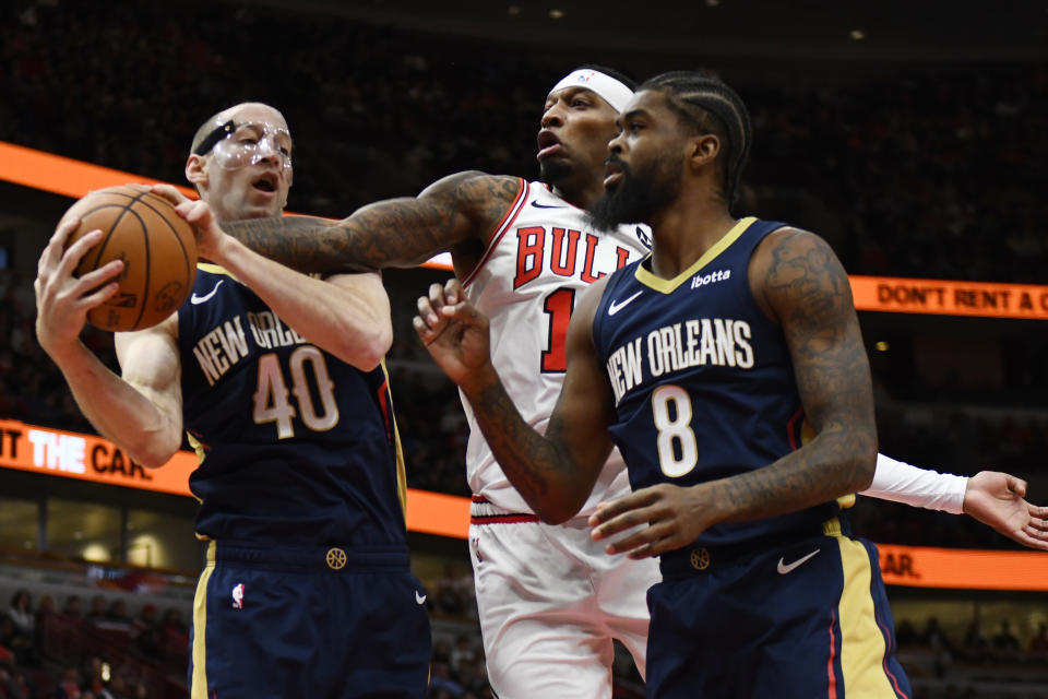 Chicago Bulls' Torrey Craig (13) battles New Orleans Pelicans' Cody Zeller (40) and Naji Marshall (8) for a rebound during the first half of an NBA basketball game Saturday, Dec. 2, 2023, in Chicago. (AP Photo/Paul Beaty)