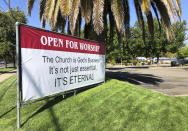 An "Open for Worship" banner is posted outside the Crossroads Community Church in Yuba City, Calif., Thursday, July 9, 2020. Sutter County was one of the first counties to reopen its economy when it defied Gov. Gavin Newsom's stay-at-home order in May to allow restaurants, hair salons, gyms and shopping malls to reopen. But Thursday, the county was added to a state watch list because of its rising number of coronavirus cases and hospitalizations. (AP Photo/Adam Beam)