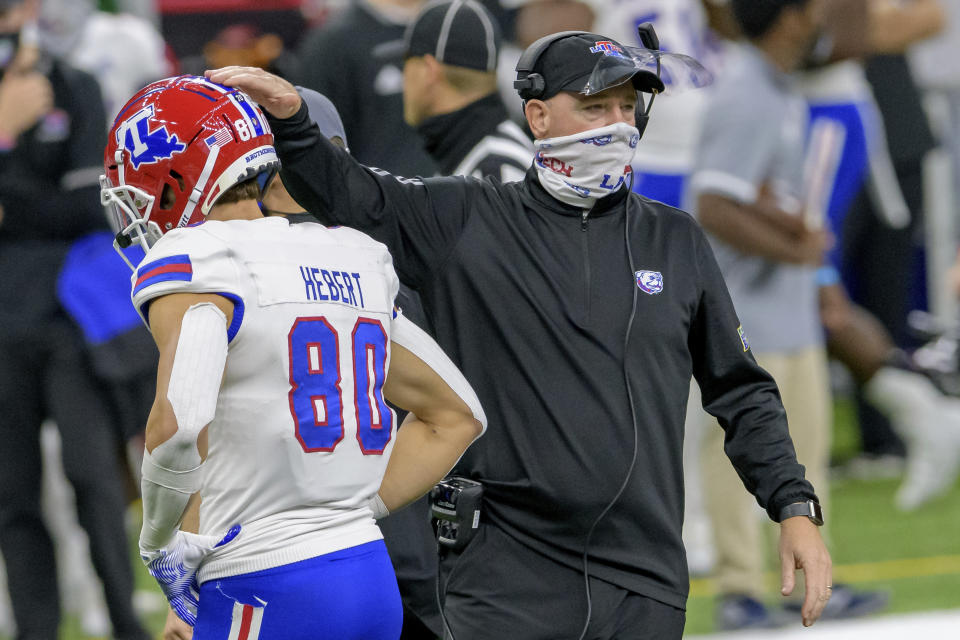 Louisiana Tech head coach Skip Holtz pats the helmet of wide receiver Griffin Hebert (80) during the first half of the New Orleans Bowl NCAA college football game against Georgia Southern in New Orleans, Wednesday, Dec. 23, 2020. (AP Photo/Matthew Hinton)