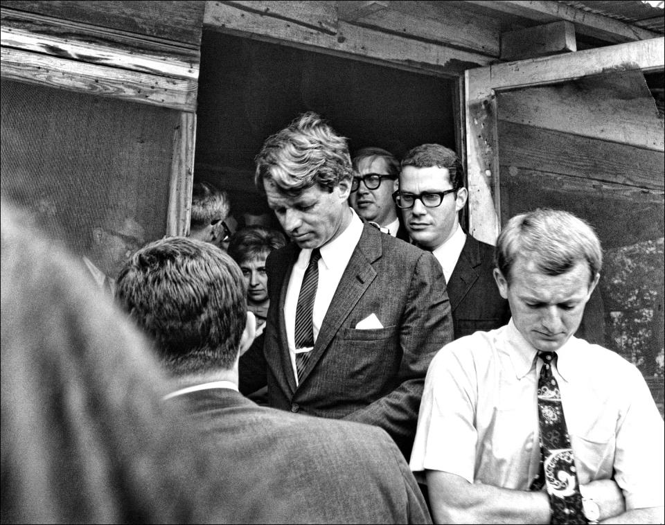 <p>Kennedy and his aide, Peter Edelman (in glasses behind Kennedy), visit several homes in Cleveland, Miss., on April 11, 1967. (Photo: Dan Guravich) </p>