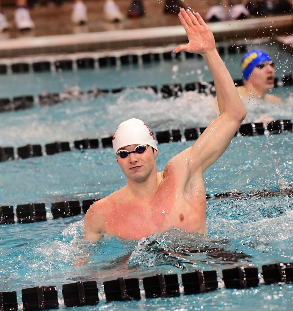 With victory secured, Gibson Holmes raises his hand as Indian Hill secures first place in the 400-yard freestyle relay at the 2023 Division II Ohio High School Athletic Association State Swimming and Diving Championships, Feb. 24, 2023.