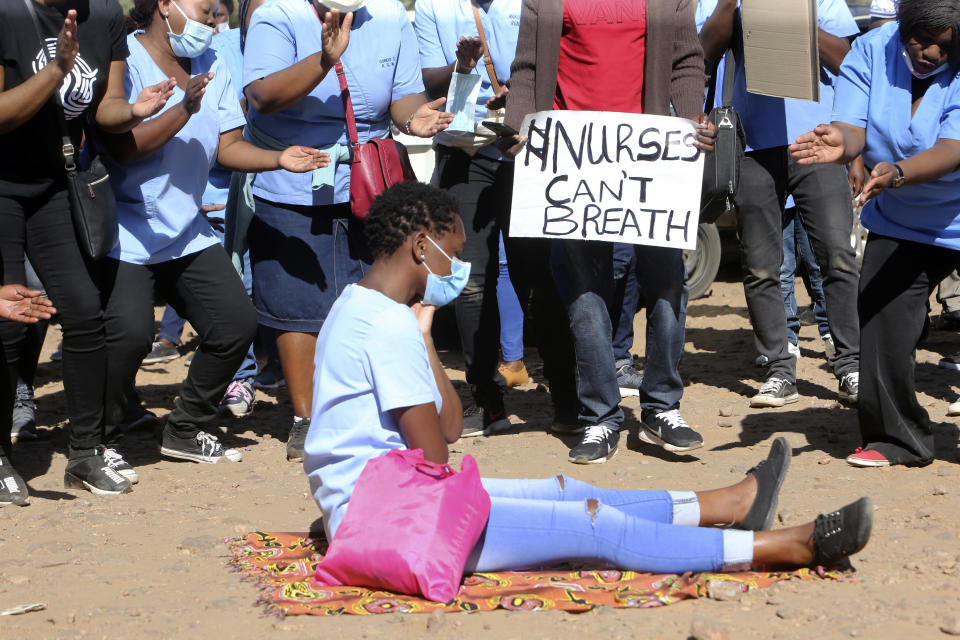 Nurses take part in a protest at a government hospital in Harare, Monday, July, 6, 2020. Thousands of nurses working in public hospitals stopped reporting for work in mid-June, part of frequent work stoppages by health workers who earn less than $50 a month and allege they are forced to work without adequate protective equipment. On Monday, dozens of nurses wearing masks and their white and blue uniforms gathered for protests at some of the country’s biggest hospitals in the capital, Harare, and the second-largest city of Bulawayo.(AP Photo/Tsvangirayi Mukwazhi)