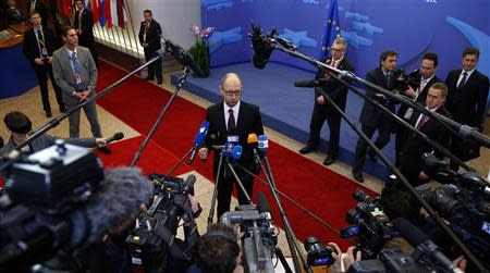 Ukraine's Prime Minister Arseniy Yatsenyuk talks to reporters while leaving a European Union leaders summit in Brussels March 21, 2014. REUTERS/Yves Herman