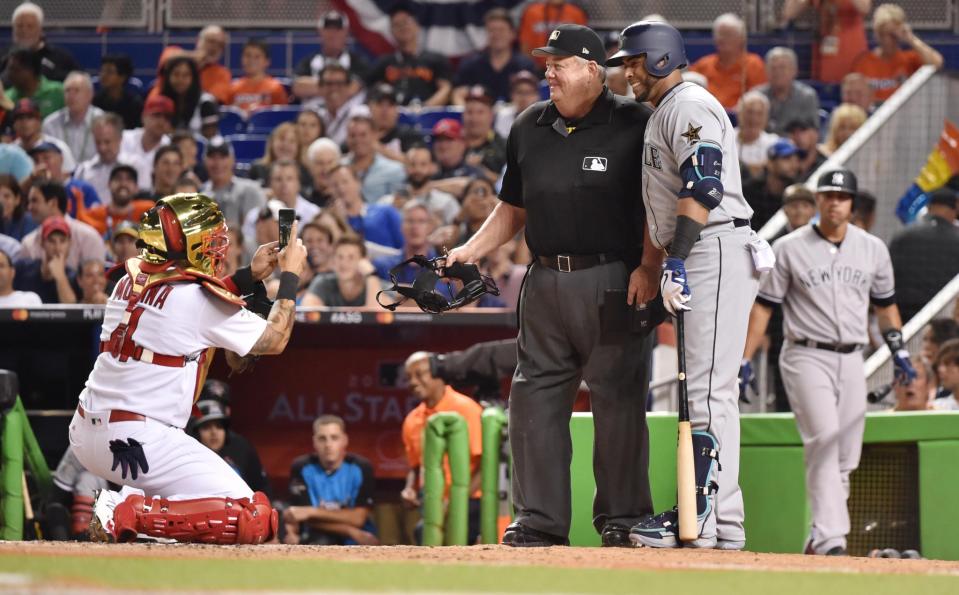 <p>National League catcher Yadier Molina (4) of the St. Louis Cardinals takes a photo of American League player Nelson Cruz (23) of the Seattle Mariners with umpire Joe West in the sixth inning during the 2017 MLB All-Star Game at Marlins Park. (Steve Mitchell-USA TODAY Sports) </p>