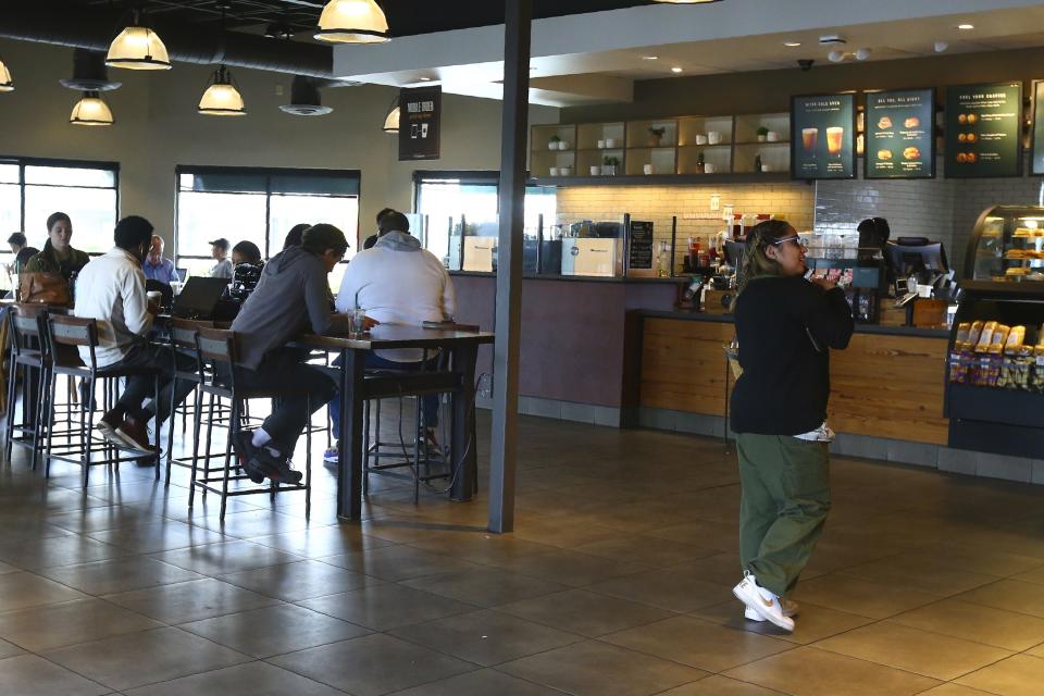 This Wednesday, Jan. 15, 2020, photo, shows patrons at a local Starbucks Community Store, in Phoenix. The larger Starbucks location has a community meeting space for events and programming, and offers local community hiring. (AP Photo/Ross D. Franklin)