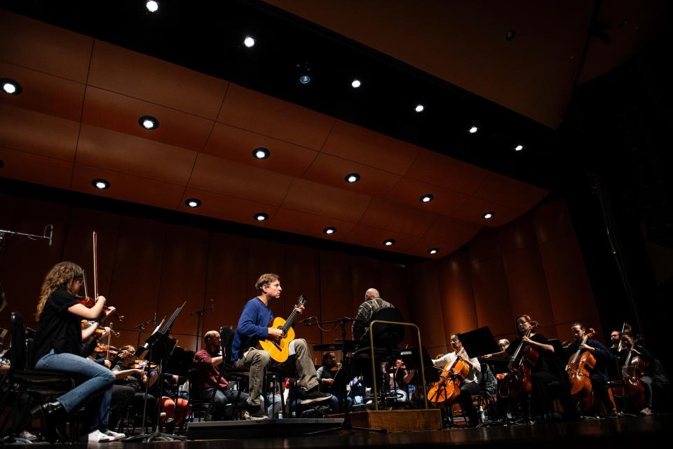 Grammy Award-winning guitarist Jason Vieaux performs, as Maestro Wes Kenney conducts the violin section during a dress rehearsal of its second Signature Concert, “Rodrigo Reverie” at the Lincoln Center in Fort Collins, Colo., on Thursday, Nov. 2, 2023. The Fort Collins Symphony turned 100 this year and is celebrating the century mark with its season "Now and Then."