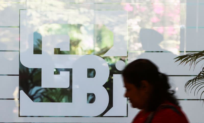 A woman walks past the logo of the Securities and Exchange Board of India (SEBI), at its headquarters in Mumbai