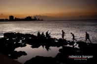 An agler fishes along the Malecon, the oceanside road in Central Havana. Boats are scarce in Cuba to keep people from exiting the country, so most of the fishing is done from land.