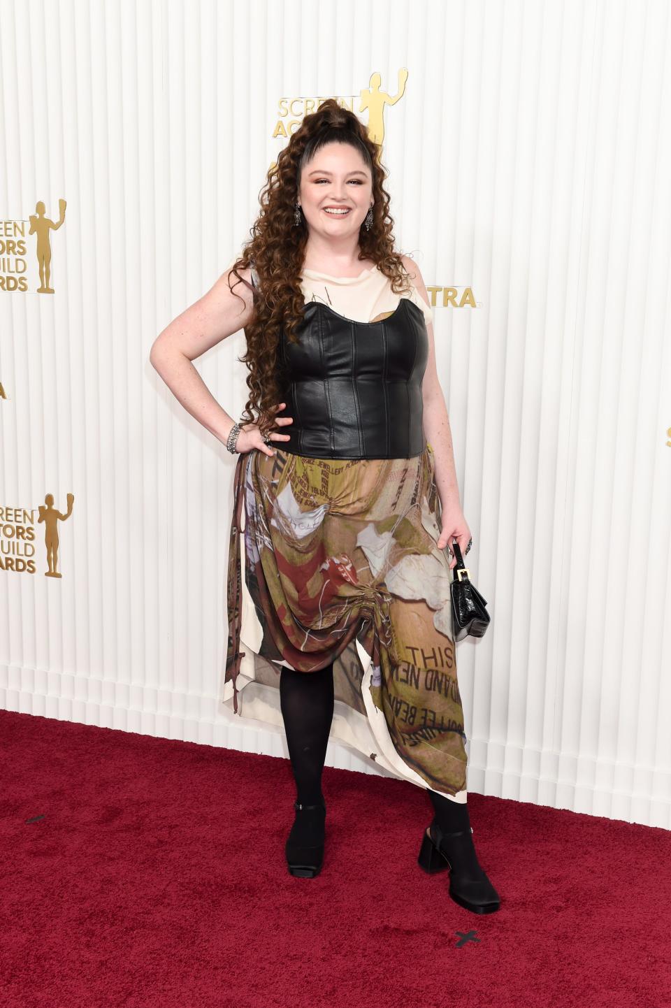 Megan Stalter wears a black corset with an asymmetric skirt on the SAG Awards red carpet.