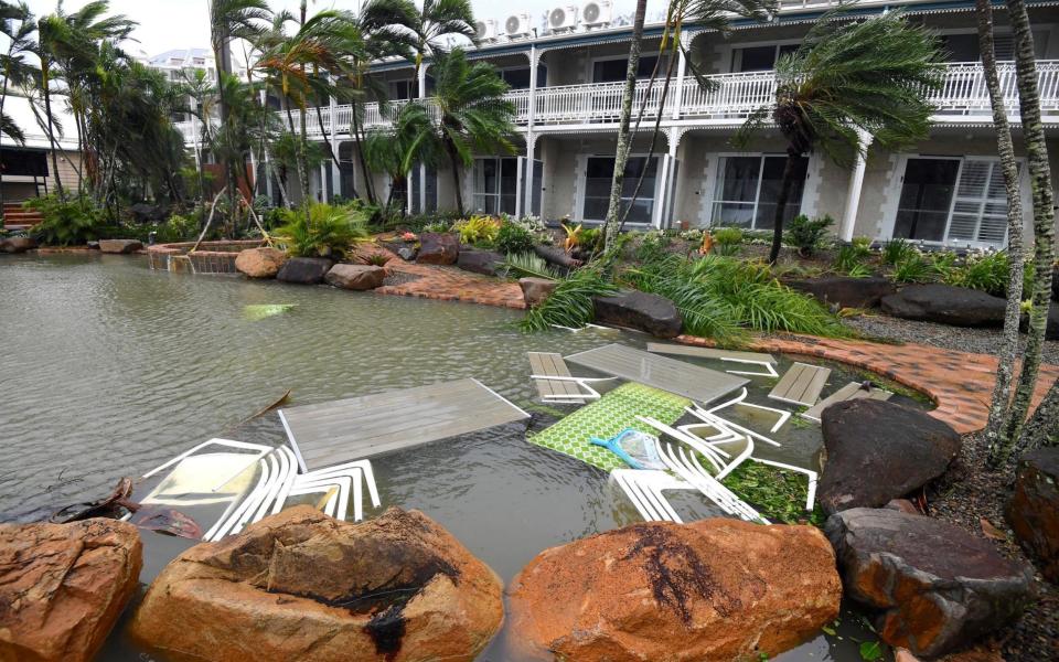 Outdoor furniture lies in a pool at a motel as Cyclone Debbie hits the northern Queensland town of Airlie Beach - Credit:  REUTERS