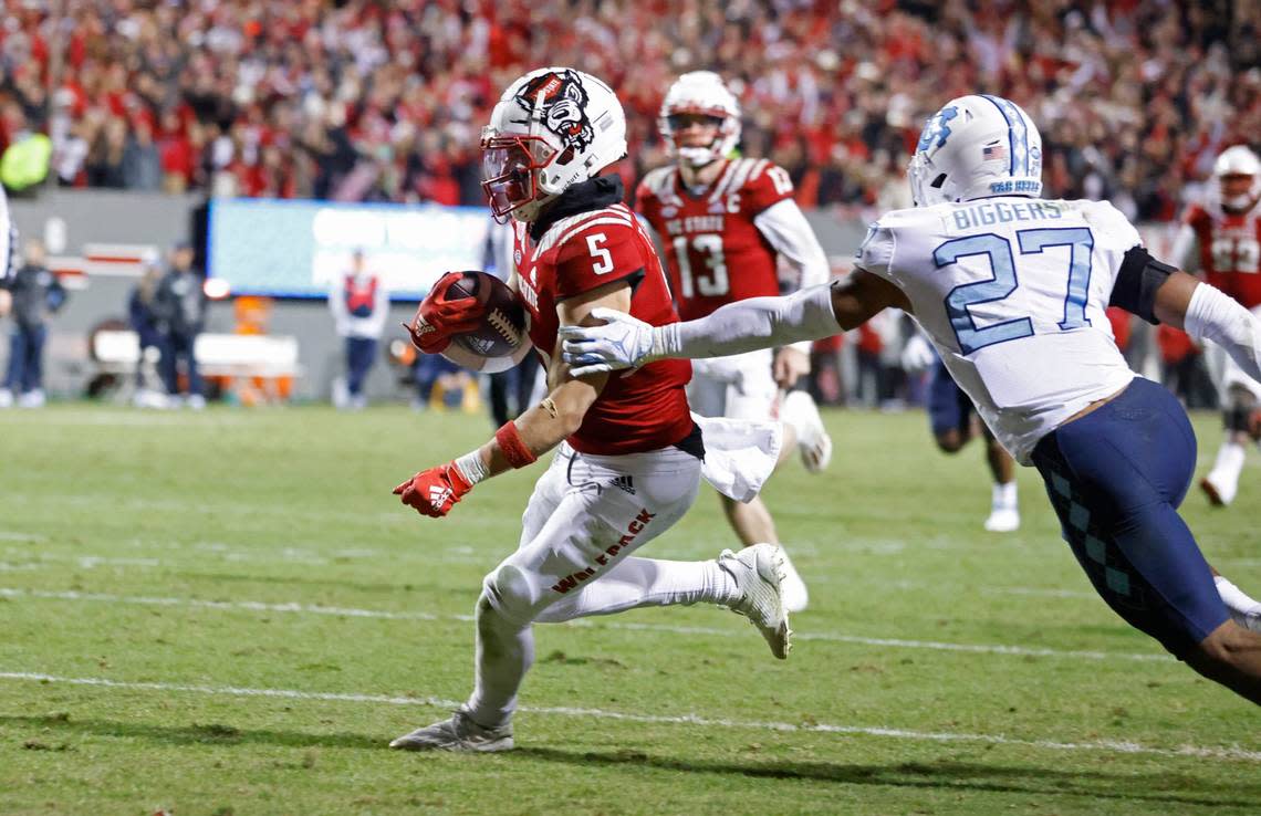 N.C. State wide receiver Thayer Thomas (5) beats North Carolina defensive back Giovanni Biggers (27) to score on a 26-yard touchdown reception during the second half of N.C. State’s 34-30 victory over UNC at Carter-Finley Stadium in Raleigh, N.C., Friday, November 26, 2021.