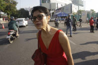 Theary Seng, a Cambodian-American lawyer, stands near the Phnom Penh Municipal Court in Phnom Penh, Cambodia, Thursday, Jan. 14, 2021. Theary Seng said Thursday she was being persecuted for her political opinion as she and dozens of other government critics charged with treason and other offenses returned to court in a trial criticized by rights advocates. (AP Photo/Heng Sinith)