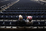 Baseball fans eat ice cream in a section of empty seats as a steady rain falls prior to the scheduled start between the Miami Marlins and Washington Nationals at Nationals Park on September 21, 2013 in Washington, DC. (Photo by Jonathan Ernst/Getty Images)
