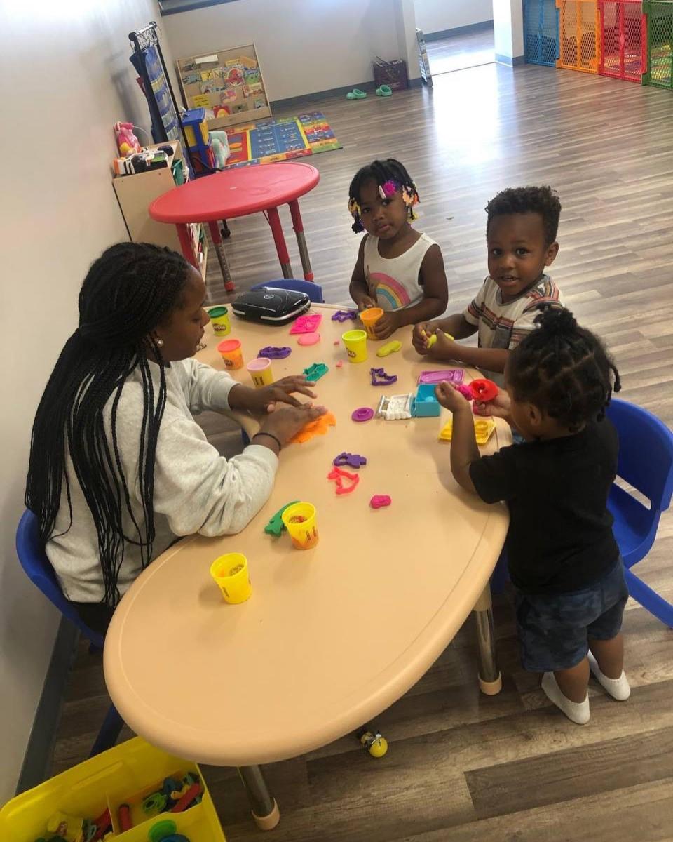 LaShay Anderson sits with children at her KandeeLand Academy, a STEAM preschool in Bristol.