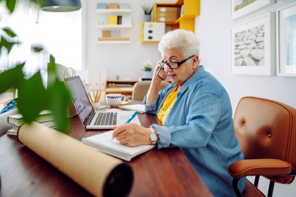 A senior citizen woman does book keeping from home. 