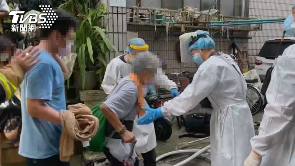 消防人員利用共生面罩將年邁住戶帶下樓。（圖／TVBS）