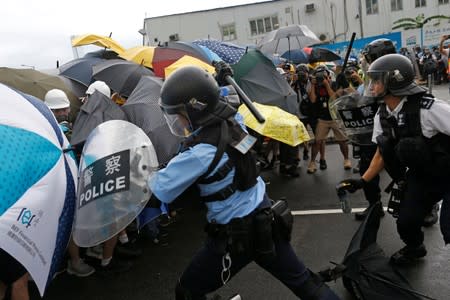 Riot police try to disperse protesters near a flag raising ceremony for the anniversary of Hong Kong handover to China in Hong Kong