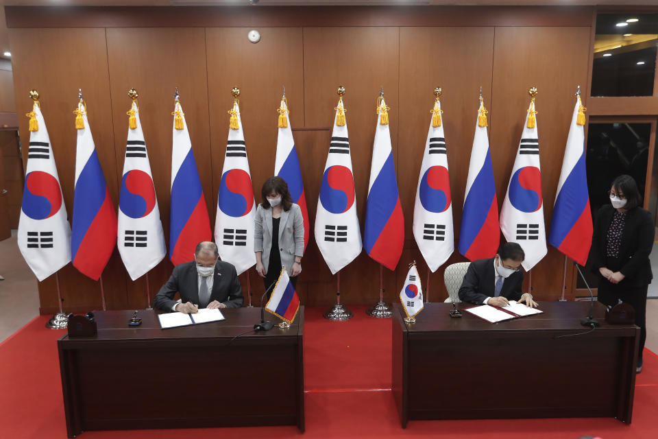Russian Foreign Minister Sergey Lavrov, left, and South Korean Foreign Minister Chung Eui-yong, second from right, sign an agreement to strengthen the bilateral ties during a joint announcement at the Foreign Ministry in Seoul, South Korea, Thursday, March 25, 2021. (AP Photo/Ahn Young-joon, Pool)